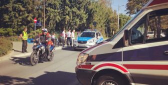 Ratownik medyczny na motocyklu oraz ambulans podczas zabezpieczenia medycznego biegu.