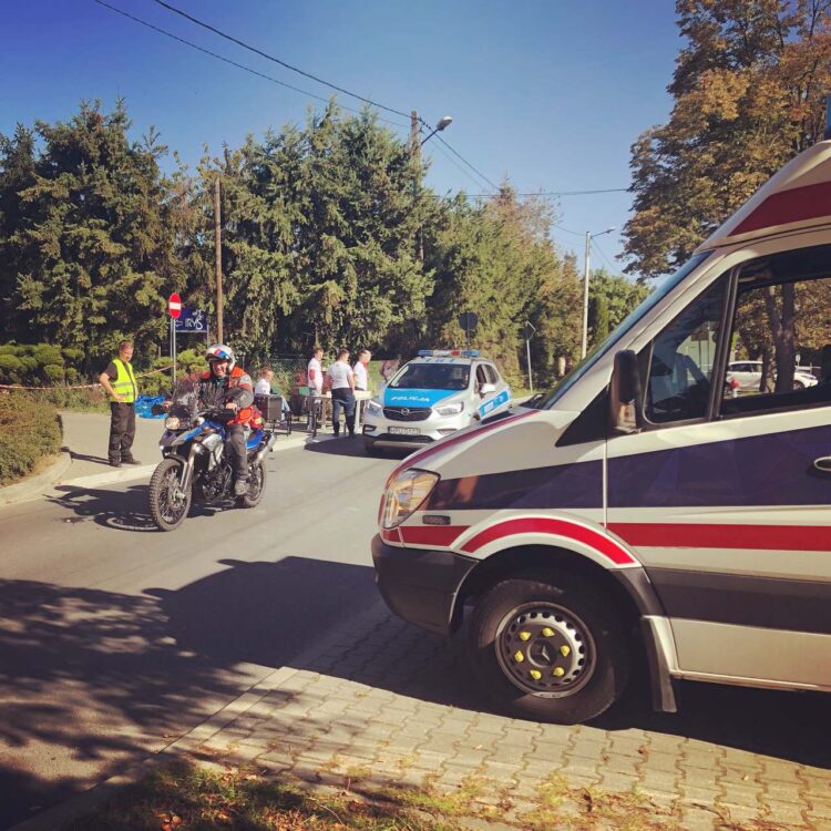 Ratownik medyczny na motocyklu oraz ambulans podczas zabezpieczenia medycznego biegu.